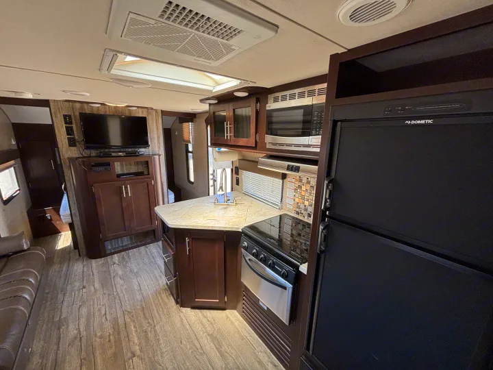 Experience comfort in this RV rental featuring a modern kitchen, living space with TV, and wood-look flooring.. Forest River Cherokee 2017