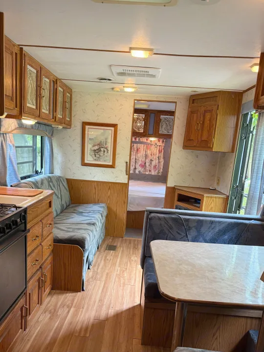 This RV rental's inviting interior features a kitchen, dinette, and glimpse of the bedroom, offering a comfortable travel space.. Jayco 300dbbh 1994