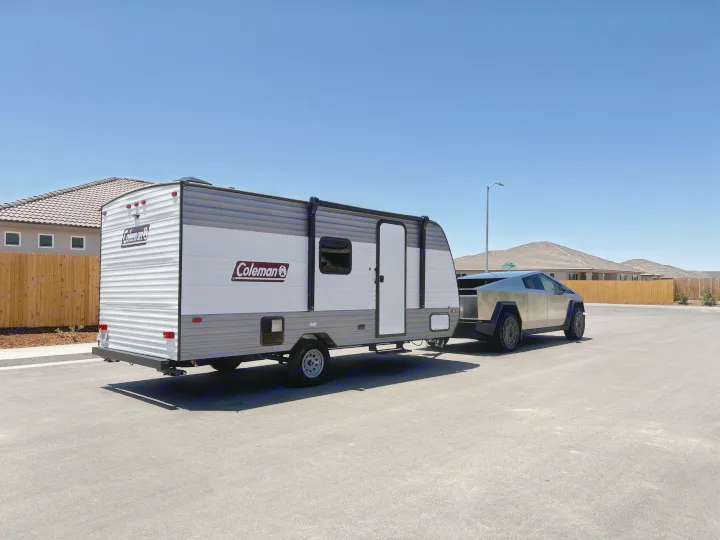 A Tesla Cybertruck tows a Coleman RV rental on a sunny day.. Dutchmen Coleman 2024