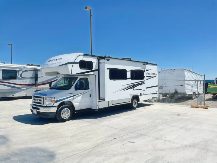 This white Sunseeker Class C rv rental is parked on a bright, sunny concrete lot, ready for your next outdoor adventure.. Forest River Sunseeker 2022