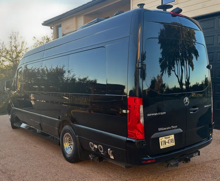 A sleek black Mercedes Sprinter camper van, possibly an rv rental, with visible hookups & a Dometic AC unit.. Ultimate Toys Ultimate RV 2021