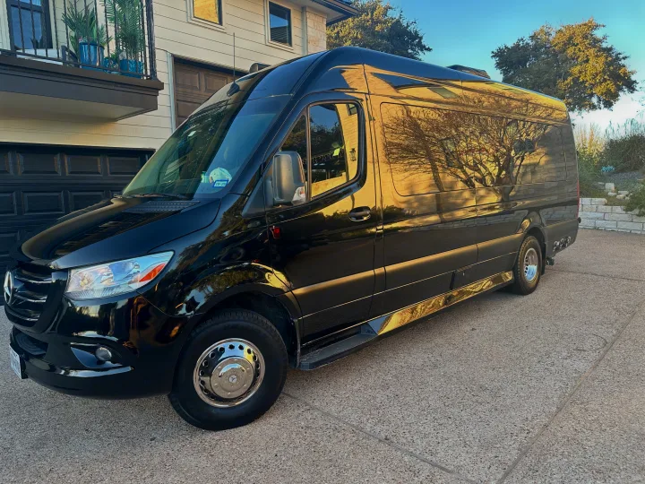 Sleek black Mercedes-Benz Sprinter conversion van, ideal for an RV rental, parked on a sunny driveway.. Ultimate Toys Ultimate RV 2021