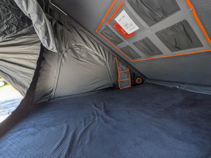 Roof tent interior for RV rental adventures: comfy mattress, overhead storage with manual, and side pockets.. Toyota Sienna 2012