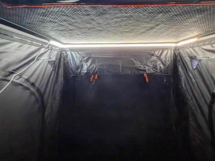 Brightly lit interior of an RV rental sleeping area with textured ceiling & dark fabric walls. LED strip provides illumination.. Toyota Sienna 2012