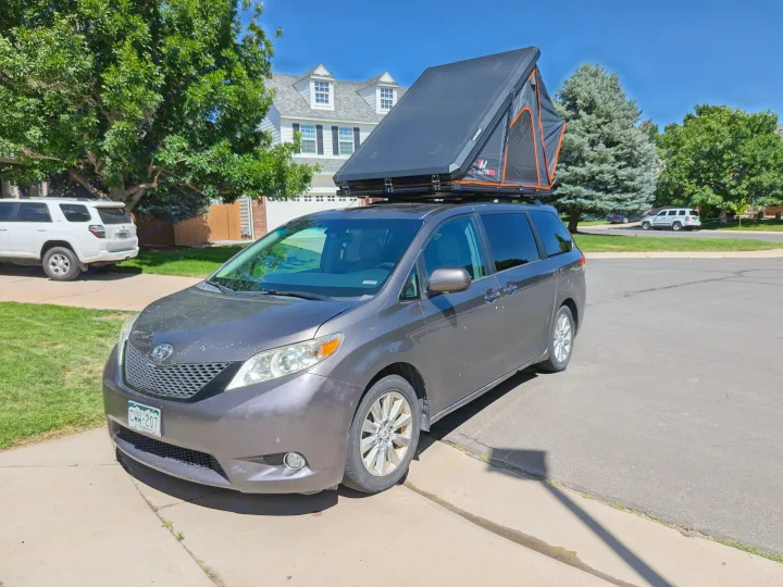 This grey minivan with a Naturhike rooftop tent makes for a unique RV rental setup for camping.. Toyota Sienna 2012