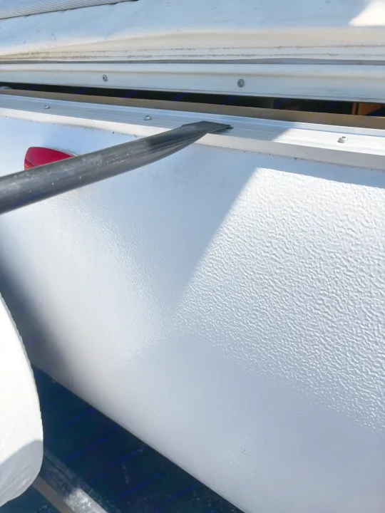 RV rental repair: A tool is used to separate the textured side panel and aluminum trim for maintenance.. Rockwood Freedom 2280 BH 2016