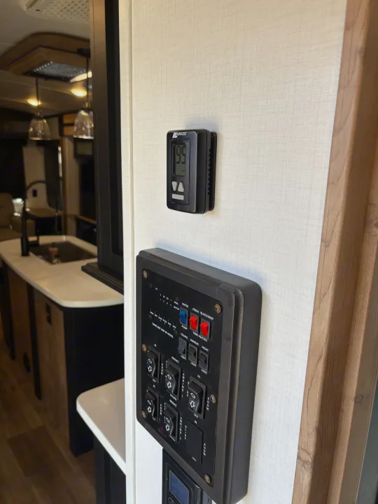 RV rental: Wall-mounted thermostat (99°F) and control panel for water, lighting, and slide-out features.. Keystone RV Outback 2022