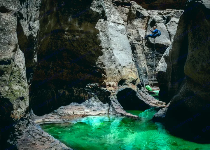 A thrilling canyoneering descent into a deep slot canyon with glowing green water. Plan your adventure with an RV rental!. Toyota Other 2025