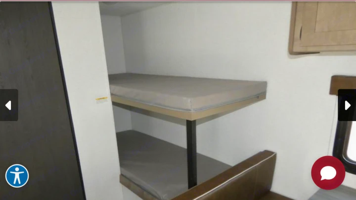 This RV rental shows a compact interior with two comfortable bunk beds, ideal for family sleeping during your travels.. Keystone Springdale 2025