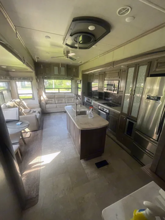 Explore this luxurious rv rental interior. Features a spacious kitchen, living area, & large windows for comfortable travel.. Cedar Creek Champagne 2019
