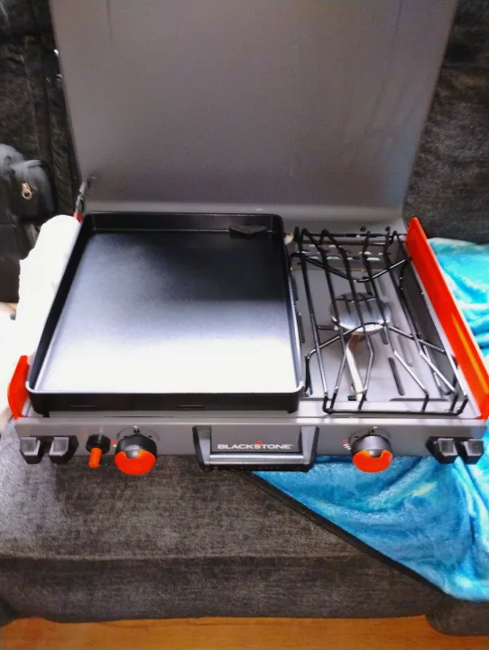 Portable Blackstone griddle/stove, perfect for your rv rental. Features a flat top and burner with orange controls.. Forest River Rockwood Ultra Lite 2016