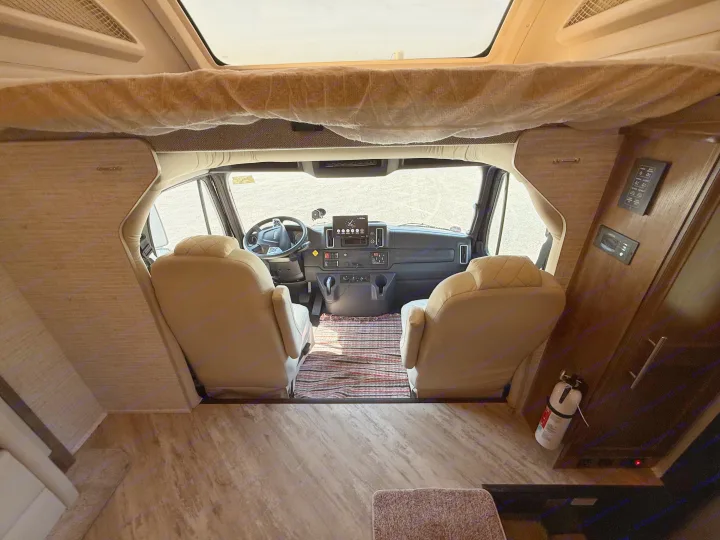 Inside this RV rental, the spacious cockpit features comfortable driver and passenger seats, an over-cab bunk, and a fire extinguisher.. Jayco Seneca 2025