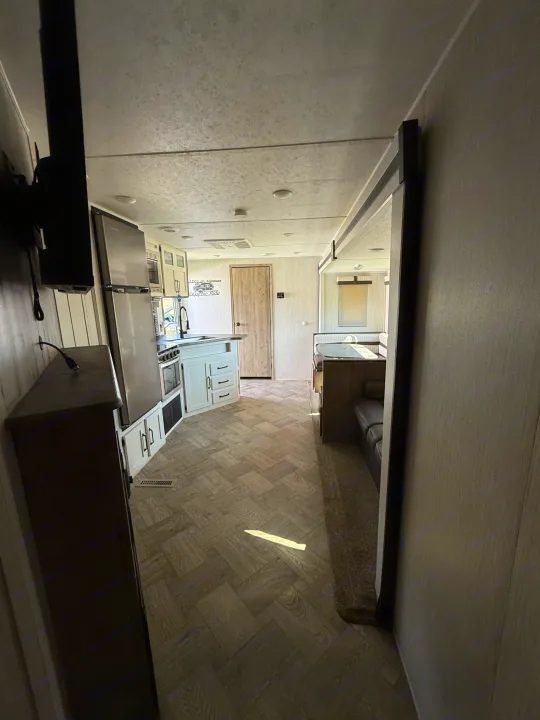 View of an RV rental's kitchen, dining booth, and living room from the entrance. Clean & ready for your next trip!. Forest River Palomino Puma 2022