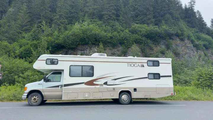 Tioga RV rental by a green forest. Ideal for scenic travel and exploring nature on your next adventure.. Tioga FTWD 2004