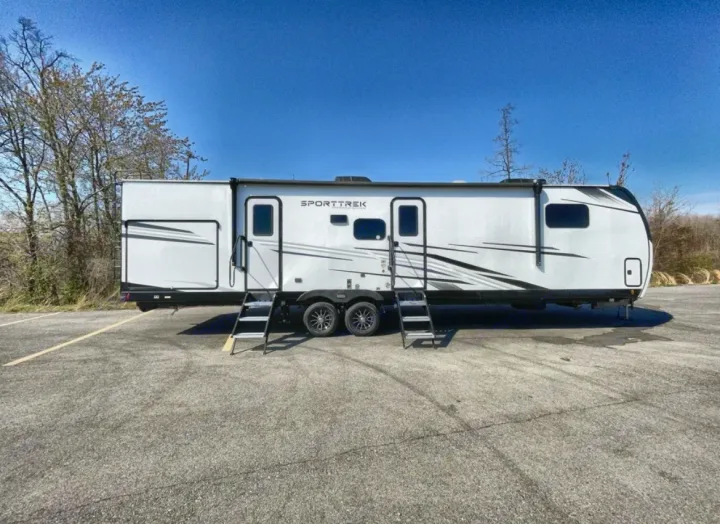 A sleek white SportTrek travel trailer with multiple entry steps, perfect for your next rv rental getaway.. Venture Rv SPORTTREK TOURING EDITION 2025