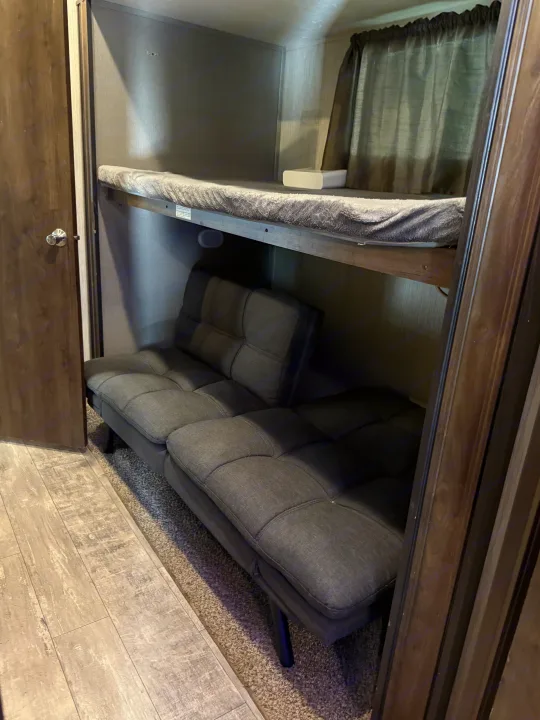 RV rental: Bunk bed over a futon for versatile sleeping/seating. Cozy interior with wood-look floor and carpet.. Crossroads RV Volante 2020