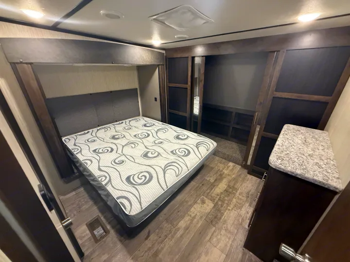 Cozy RV rental bedroom with queen bed, built-in storage, and modern finishes for comfortable travel.. Crossroads RV Volante 2020