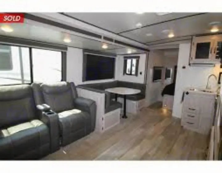Spacious RV rental interior, featuring comfortable recliners, a dinette, and kitchen. Ideal for your next adventure!. Coachmen 2557RB 2021