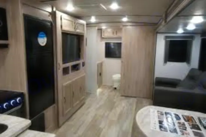 Spacious RV rental interior showcasing a modern kitchen, comfortable living area, and rear bathroom. Ideal for travel and vacations.. Coachmen 2557RB 2021