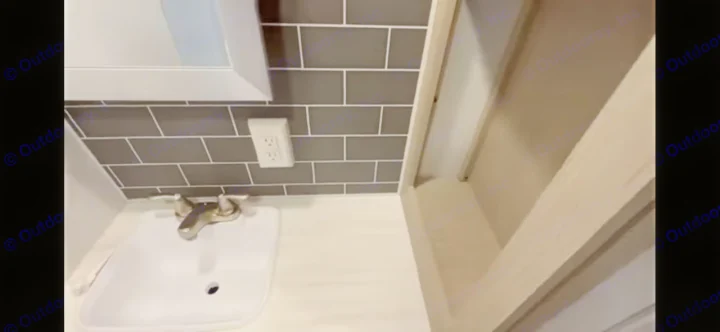 RV rental bathroom features: White sink, modern faucet, dark gray subway tile backsplash, and an electrical outlet.. Forest River Salem View 2024