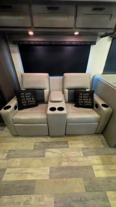 Modern RV rental interior with gray reclining seats, cup holders, and humorous 'parking the camper' pillows.. FR3 FR3 Motorhome 2022
