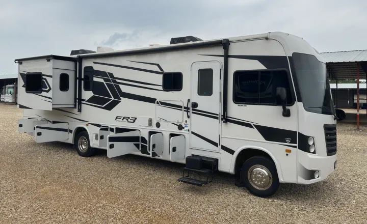 White Forest River FR3 RV rental with extended slide-outs and open storage bays, parked on gravel. Ready for travel!. FR3 FR3 Motorhome 2022
