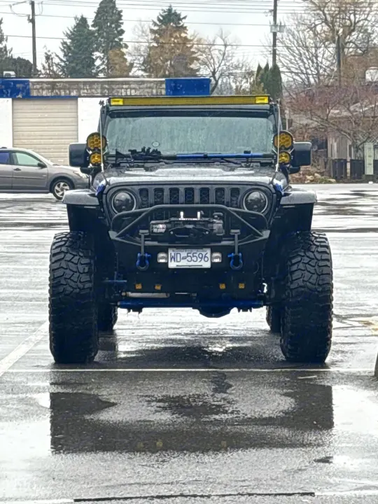 A rugged black modified Jeep Wrangler, adventure-ready. This vehicle pairs well with an rv rental for off-road exploration.. Dodge Jeep Unlimited X 4x4 2021