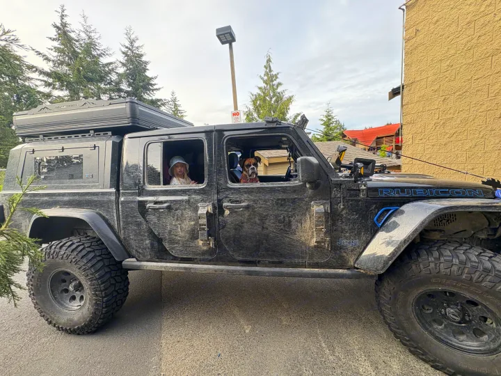 Muddy Jeep Gladiator with rooftop tent (OVE Everest), child, and dog, an ideal RV rental for off-road family adventures.. Dodge Jeep Unlimited X 4x4 2021