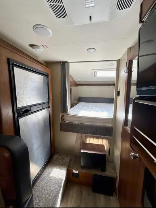 Experience comfort in this RV rental! Interior features a large fridge, elevated bedroom, and compact living space.. Lance 1172 2017