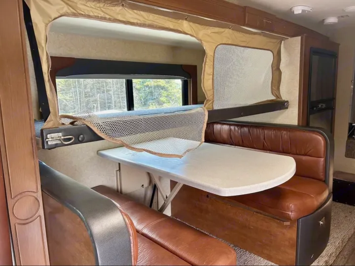 RV rental interior: A cozy dinette with a fold-down bunk bed above, ready for adventure.. Lance 1172 2017