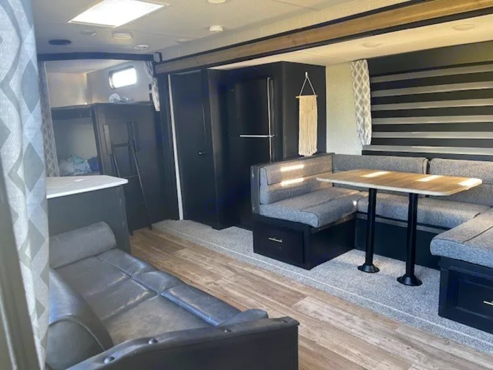 RV rental: Modern interior with U-shaped dining booth, sofa, and bunk beds.. Forest River Cherokee 2022