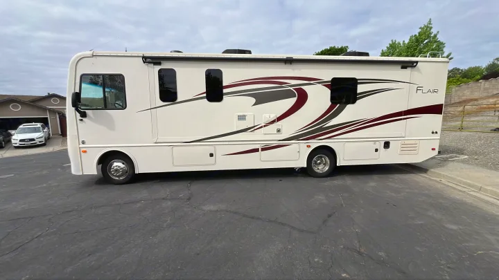 This white Flair RV rental is parked on asphalt, ready for your next adventure.. Flair-Fleetwood Flair-Fleetwood Motorhome 2020