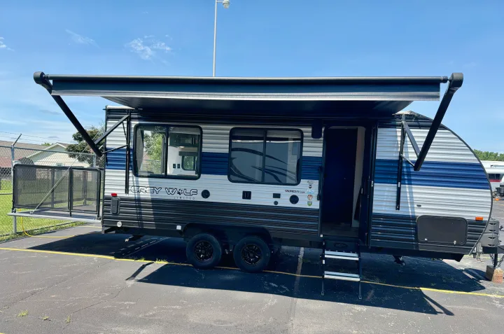 Grey Wolf travel trailer rv rental, shown with extended awning & rear patio. Perfect for camping adventures!. Forest River Grey Wolf 2021