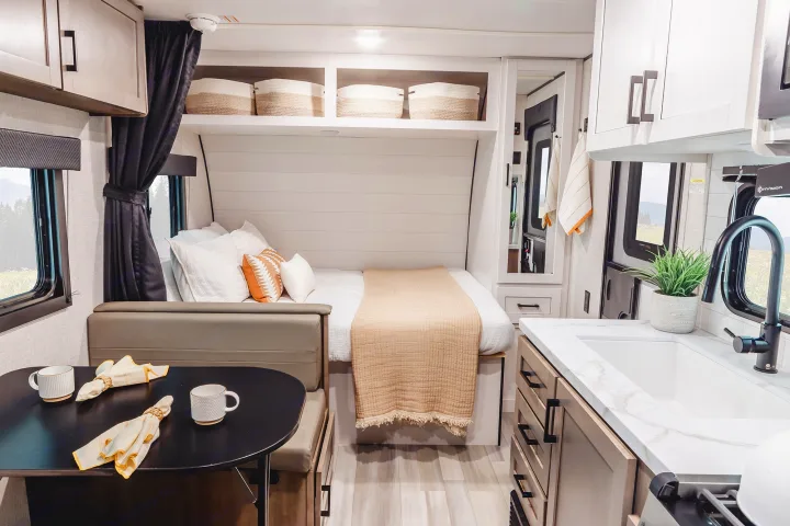 Spacious RV rental interior featuring a bright kitchen, comfortable bed, and dinette area with scenic window views.. Wayfinder RV Go Play 19BH 2025