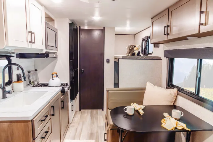Spacious RV rental interior featuring a modern kitchen, comfortable dinette, and cozy bunk beds. Perfect for family adventures.. Wayfinder RV Go Play 19BH 2025