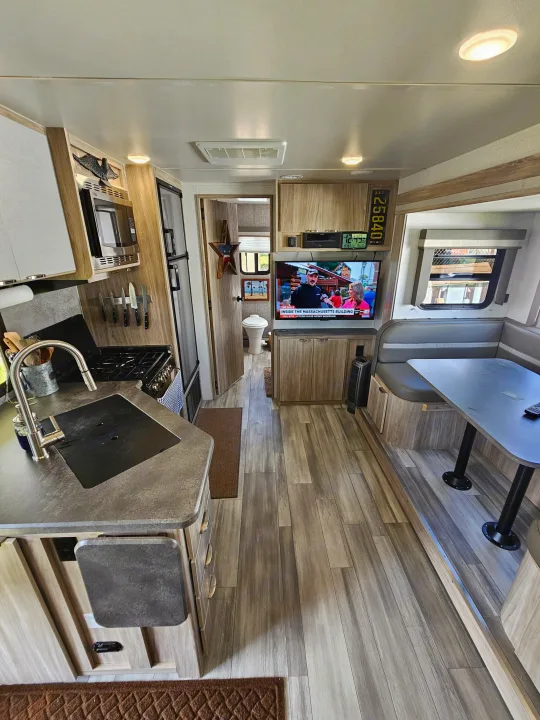 Spacious RV rental interior with a full kitchen, comfortable dinette, and private bathroom, ideal for travel living.. Winnebago Minnie 2201MB 2022
