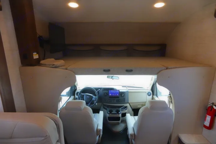 This RV rental features a spacious interior with an overhead bunk, a full cockpit view, and comfortable swivel seats.. Jayco Redhawk 2021