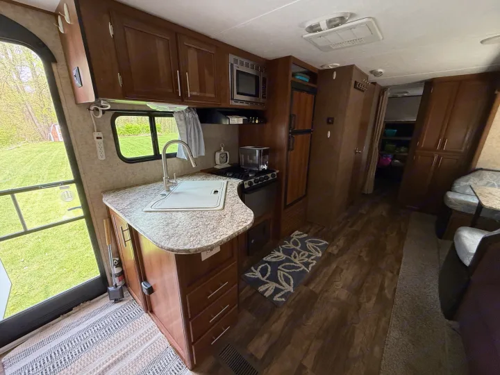 Inside an RV rental: full kitchen, comfy living space, and outdoor views.. Forest River Tracer Air 2016