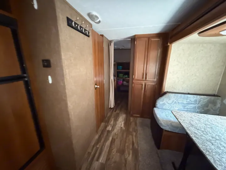 Spacious RV rental interior featuring a hallway, kitchen area, and dining booth. Ideal for road trips.. Forest River Tracer Air 2016