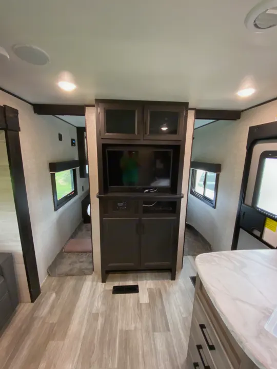 Step inside this RV rental's well-appointed interior, showcasing a central media hub, sleek kitchen counter, and wood-look floors.. Jayco Jay Flight SLX 2022