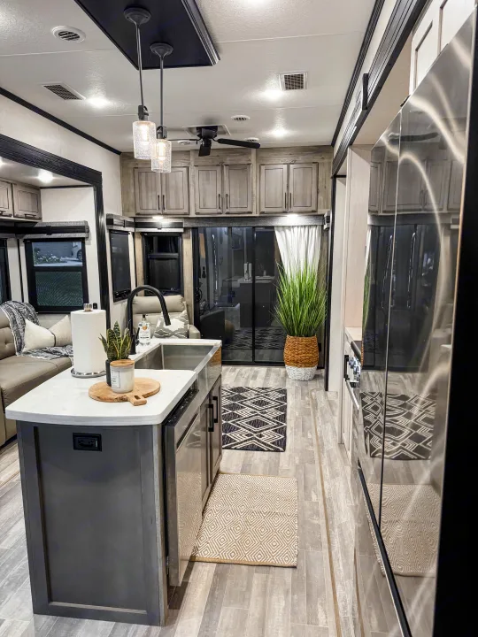 Modern RV rental interior with a spacious kitchen island, comfortable living area, and chic decor, perfect for travel.. Durango Gold 2023