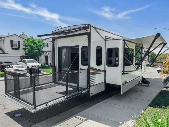 This RV rental features an extended patio, awnings, and slide-outs, creating a spacious outdoor living area at home.. Durango Gold 2023
