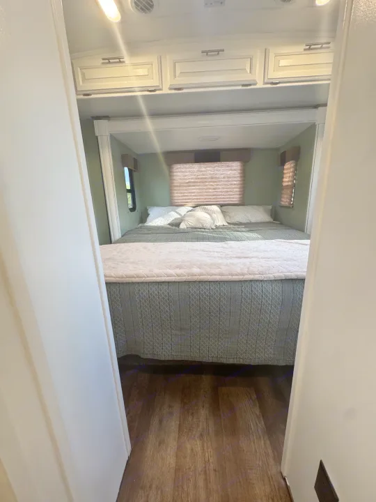 Step into this inviting RV rental bedroom featuring a comfortable bed, overhead storage, and natural light from windows.. FR3 FR3 Motorhome 2016