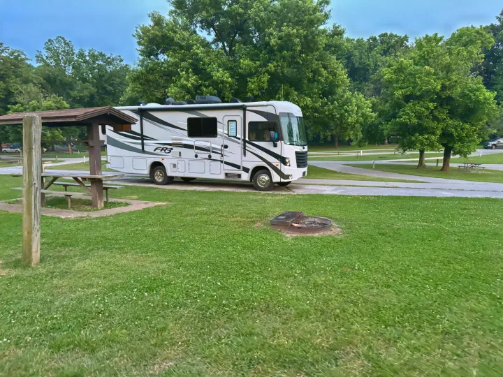 White and grey RV rental at a green park campsite, with a wooden picnic shelter and fire pit.. FR3 FR3 Motorhome 2016