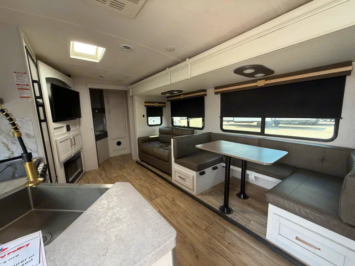 Modern RV rental: a bright interior featuring a kitchen sink, comfortable sofa, and dinette with table.. Astoria Astoria Trailer 2022