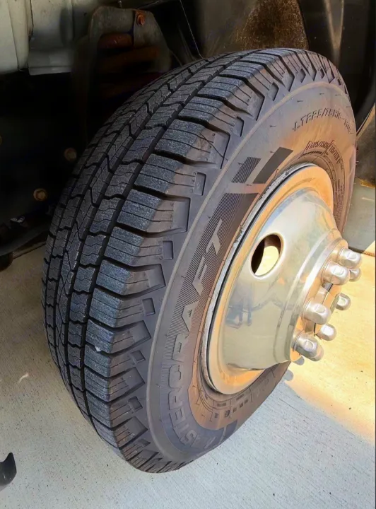 Durable tire on an RV rental vehicle, showcasing its deep tread and dually wheel with multiple lug nuts.. Forest River Coachmen Freelander 2017