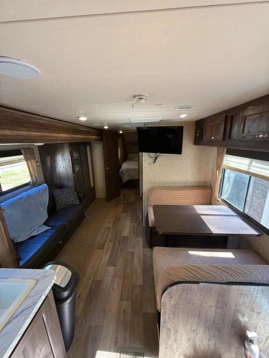 Inside this modern RV rental: a spacious living area with sofa, dinette, full kitchen, and a comfortable rear bedroom.. Forest River Vibe Extreme Lite 2017