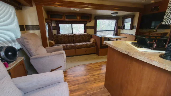 Comfortable RV rental interior with living area, recliners, sofa, dining booth, and partial kitchen view.. Coachmen salem 2013