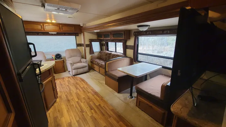 RV rental interior features a kitchen, living area with recliner & sofa, and dining booth. Ready for your travels.. Coachmen salem 2013