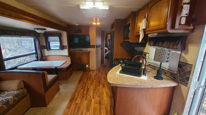 Explore this cozy RV rental interior: a functional kitchen, comfy dinette, and bright living area await your travel.. Coachmen salem 2013